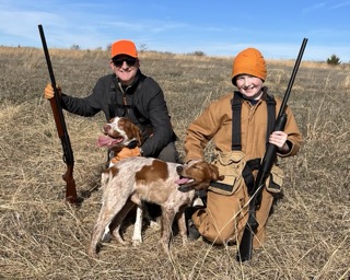 Two hunters with bird dogs in a Kansas field